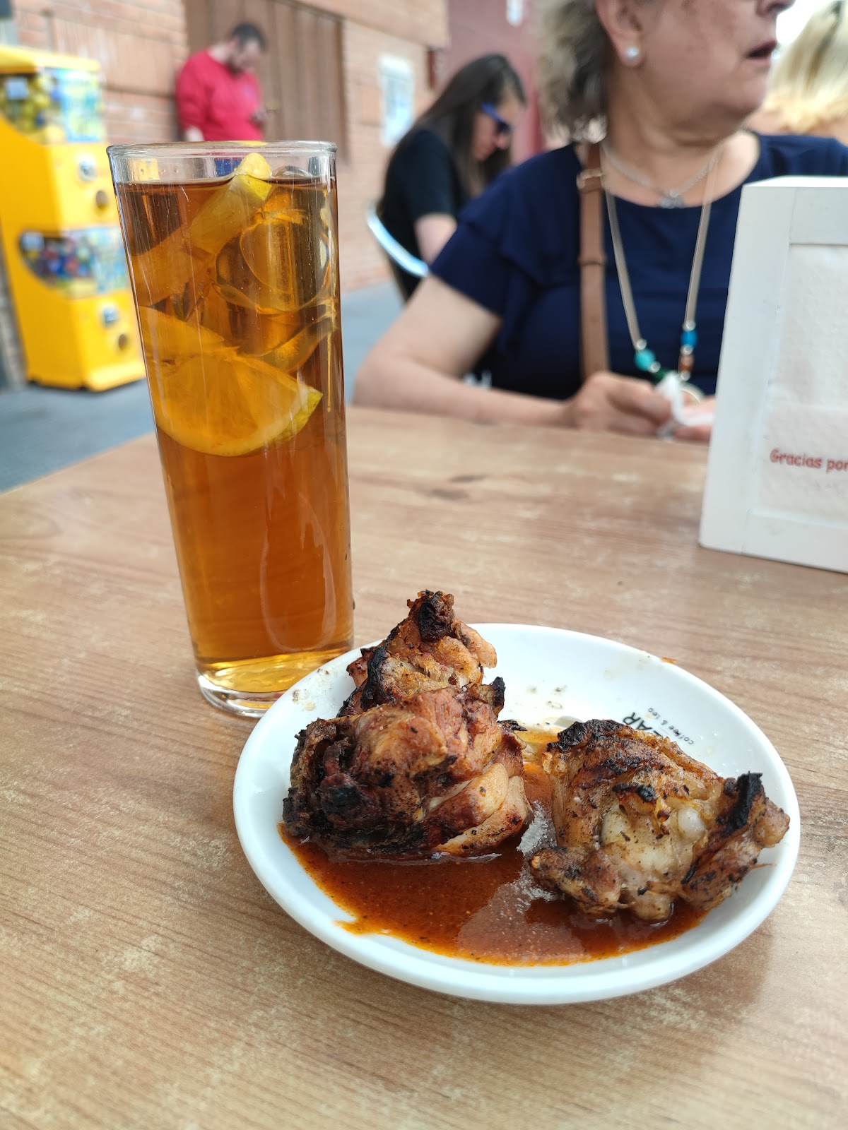 Vaso de té helado con limón y plato de pollo asado